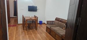 a living room with a couch and a table at Prakrithi Luxe Retreat in Padinjarathara