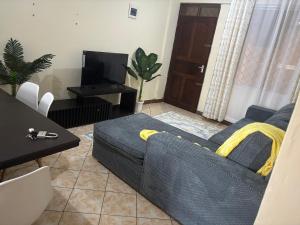 a living room with a couch and a table at AMTWAPA 2 bedroom pure blissful apartment ready to accommodate you and your family friends or colleagues in Mtwapa