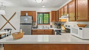 eine Küche mit Holzschränken und weißen Geräten in der Unterkunft Hygge Home by AvantStay Deck for Outdoor Living Fire Pit Game Table in Blakeslee