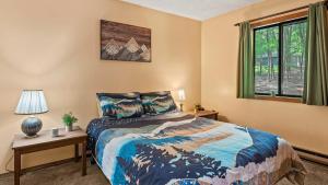 ein Schlafzimmer mit einem Bett und einem Fenster in der Unterkunft Hygge Home by AvantStay Deck for Outdoor Living Fire Pit Game Table in Blakeslee