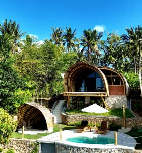 a building with a pool and chairs and trees at Marilea Bamboo Villas Concept , Private pool, seaview, Adults only in Nusa Penida
