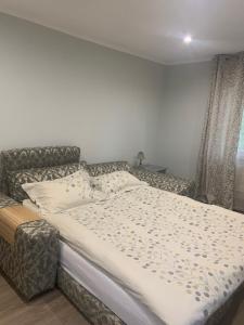 a bed in a bedroom with a couch and a window at Apartment in a quiet area, near the sea and forest in Jūrmala +5 photos
