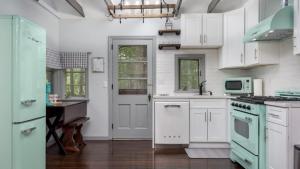une cuisine avec des armoires blanches et des appareils électroménagers verts dans l'établissement The Biddle House by AvantStay Breathtaking Views Walk to Lake, à Lake Harmony 14 autres photos