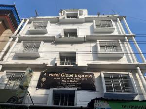 a white building with a sign on it at Hotel Globe Express in Kolkata