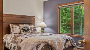 a bedroom with a bed and a window at Tranquil Waterside by AvantStay Lakefront Dock Game Room Views in Pocono Summit