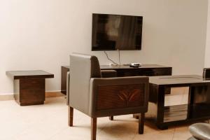 Una sala de estar con una silla, un escritorio y un televisor. en Spine lobster, en Dar es Salaam 24 fotos más