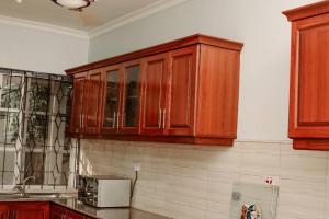 una cocina con armarios de madera en la pared en Spine lobster, en Dar es Salaam