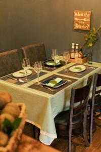 a table with a white table cloth and wine glasses at Như Là Home in Khu Chi Lăng