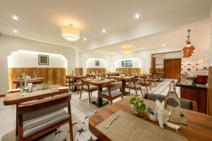 a dining room with wooden tables and chairs at The Liverpool Hotels Marathahalli, Outer Ring Road in Bengaluru