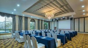 上海市にあるNew Century Manju Hotel Shanghai New International Expo Centerの青いテーブルと白い椅子が備わる宴会場
