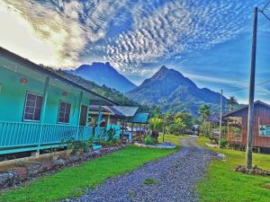 una casa con una montaña al fondo en Tambatuon Homestead, en Kota Belud