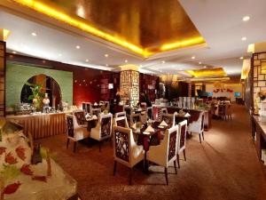 a restaurant with tables and chairs in a room at Gaosu New Century Hotel International Anhui in Hefei