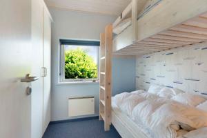 a bedroom with a bunk bed and a window at Dejlig Feriebolig Nær Strand, Skov Og Åbne Marker in Karrebæksminde