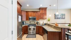 Una cocina con gabinetes de madera y electrodomésticos de acero inoxidable. en Highland Hideaway by AvantStay Group Poconos Retreat w Patio Game Room, en Lake Harmony
