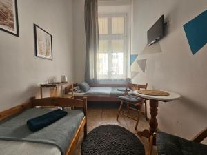 a room with two beds and a table and a window at Deja Vu Hostel in Warsaw