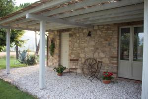 a stone house with a wooden pergola at Agriturismo Alle Mignole in Vicolo Rancolfo +56 photos