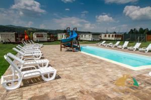 a group of lounge chairs and a slide by a pool at Nemeth Camping Spa & Pool Access in Sovata