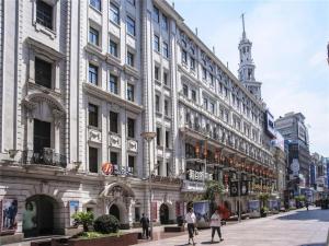 a large white building with people walking in front of it at Jinjiang Inn Select Shanghai Nanjing Road Pedestrian Street in Shanghai