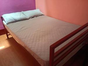 Una cama con sábanas blancas y una almohada. en Chayagruha Homestay- Home in the shade, en Avathi