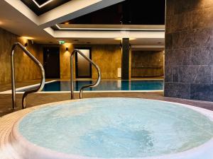 a hot tub in a hotel room with a swimming pool at Sanatorium Rosomak in Ustroń