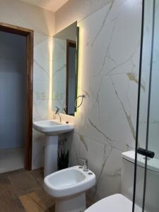 une salle de bain avec un lavabo, des toilettes et un miroir dans l'établissement paraíso paraguayo, à San Bernardino