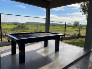 une table de billard sur une terrasse avec vue sur un champ dans l'établissement paraíso paraguayo, à San Bernardino