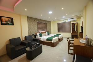 a hotel room with a bed and a couch and a desk at Builda Park inn in Ottappālam