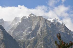 a mountain covered in snow and clouds in the sky at Mont'Arte - Private Art retreat Villa in Buşteni