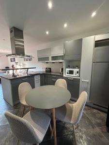 een keuken met een tafel en stoelen in een keuken bij Colmar joli petit appartement in Colmar