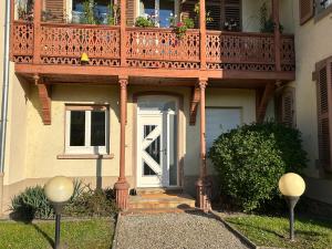 een huis met een houten balkon en een witte deur bij Colmar joli petit appartement in Colmar