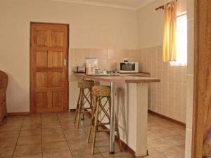 a kitchen with a counter with stools and a microwave at Robs Place in Potchefstroom