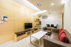 a living room with a couch and a tv at 謙匯國際酒店式公寓 CH Service Apartment in Taipei