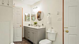 a bathroom with a toilet and a sink and mirrors at Mews Mountain House by AvantStay Walk to Beach Hot Tub Game Room in Albrightsville +55 photos
