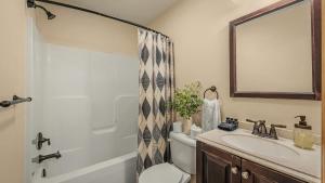 a bathroom with a sink and a toilet and a mirror at Hickory Haven by AvantStay Hot Tub Game Room Theater Deck in Albrightsville +35 photos