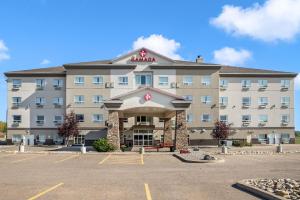 a hotel with a parking lot in front of it at Ramada by Wyndham Lac La Biche in Lac La Biche