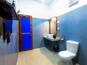 a blue bathroom with a toilet and a sink at Lily Safari Resort Udawalwa in Udawalawe +64 photos
