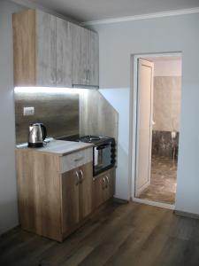 ヴェリコ・タルノヴォにあるLeon Rent Studio 8のキッチン(木製キャビネット、コンロ付)