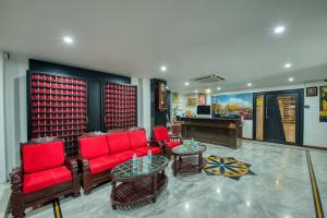 a living room with red furniture and a piano at Corbelli Residency in Puducherry