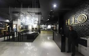 a man in a suit is standing in a lobby at The Hulo Hotel & Gallery in Kuala Lumpur