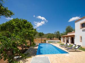 een villa met een zwembad en een huis bij Can Cama in Santa Gertrudis de Fruitera