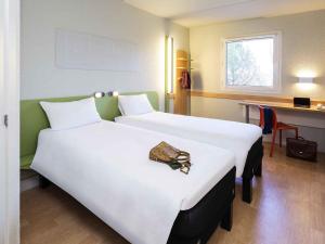 a hotel room with two beds with a bag on them at Ibis Budget Madrid Alcorcón Móstoles in Alcorcón +48 photos