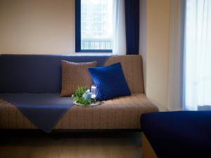 a couch with blue pillows and a tray with candles at Minn Umeda East in Osaka +3 photos