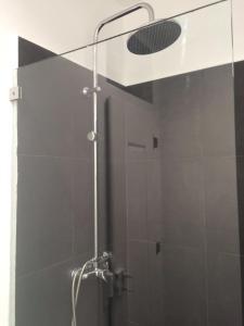 eine Dusche mit Duschkopf in einem Badezimmer in der Unterkunft A Terrace on a Topfloor with a View in Lissabon