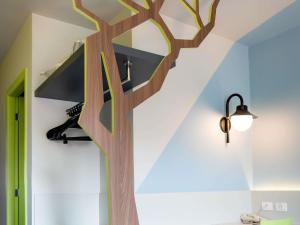 a wooden tree is on the wall of a house at ibis Styles Curitiba Centro Civico in Curitiba