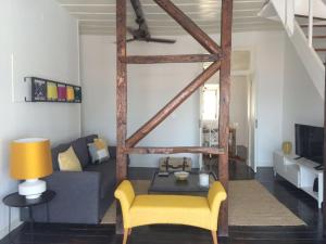 ein Wohnzimmer mit einem Sofa und einem gelben Stuhl in der Unterkunft A Terrace on a Topfloor with a View in Lissabon