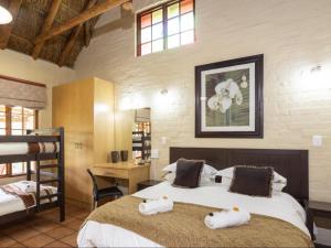 a bedroom with two beds with towels on them at Stonebreaker Country Lodge in Oudtshoorn