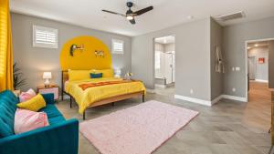 1 dormitorio con 1 cama amarilla y 1 sofá azul en Kaleidoscope by AvantStay Colorful Escape Pool, en Indio