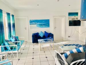 a living room with blue chairs and a couch at A Heavenly View in Muizenberg