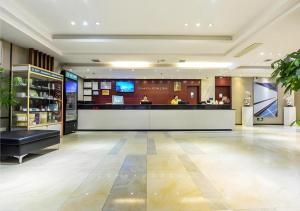 a lobby with a bar in the middle of a building at City Comfort Inn Hotel Guiyang Normal University Yangmingci Metro Station in Guiyang
