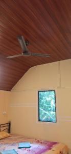 a bedroom with a ceiling fan and a window at green Garden Resort in Canacona